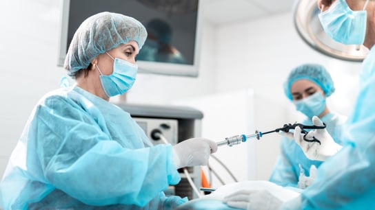 合规管理 - 女医务工作者在手术过程中帮助医生