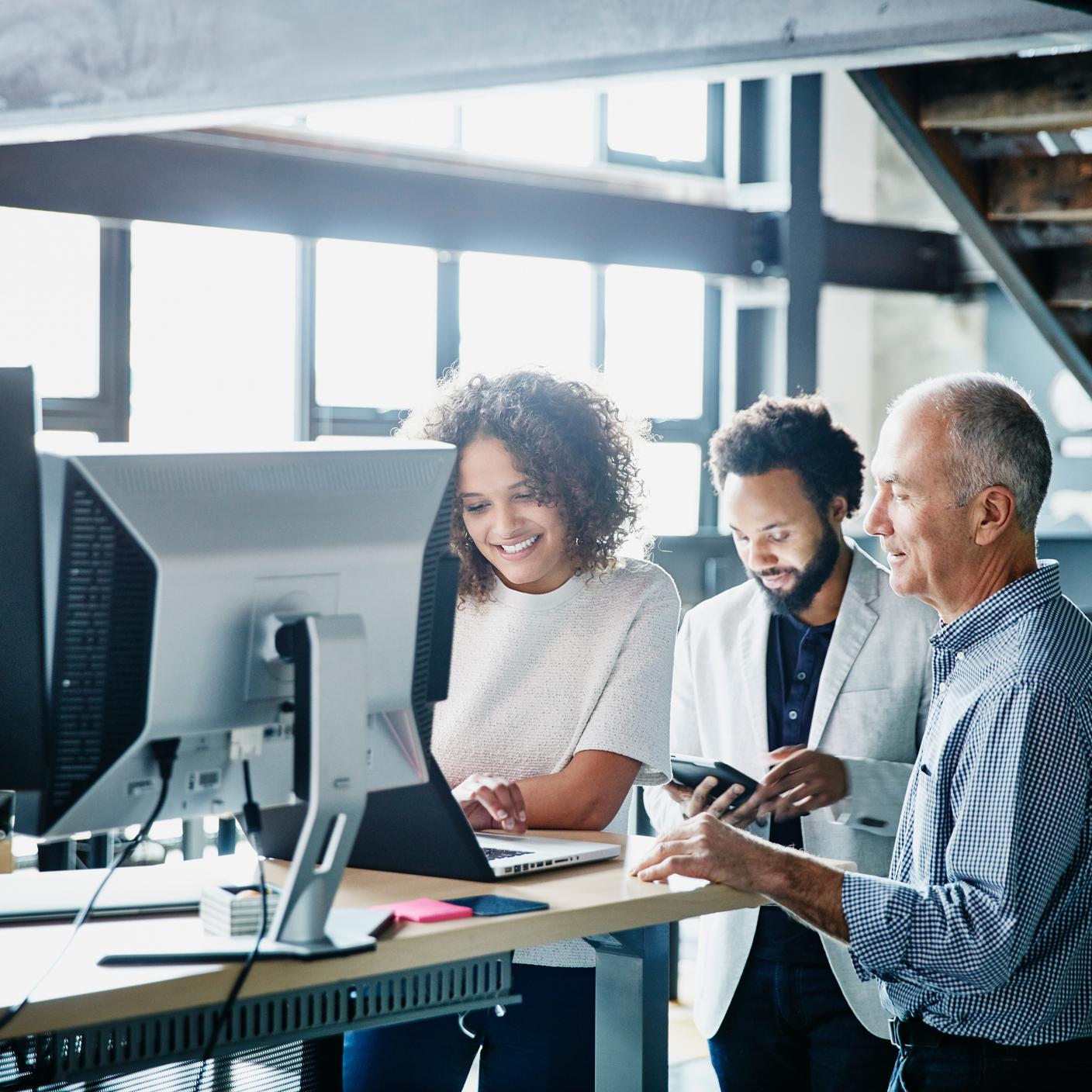 同事们在高科技办公室用笔记本电脑讨论项目