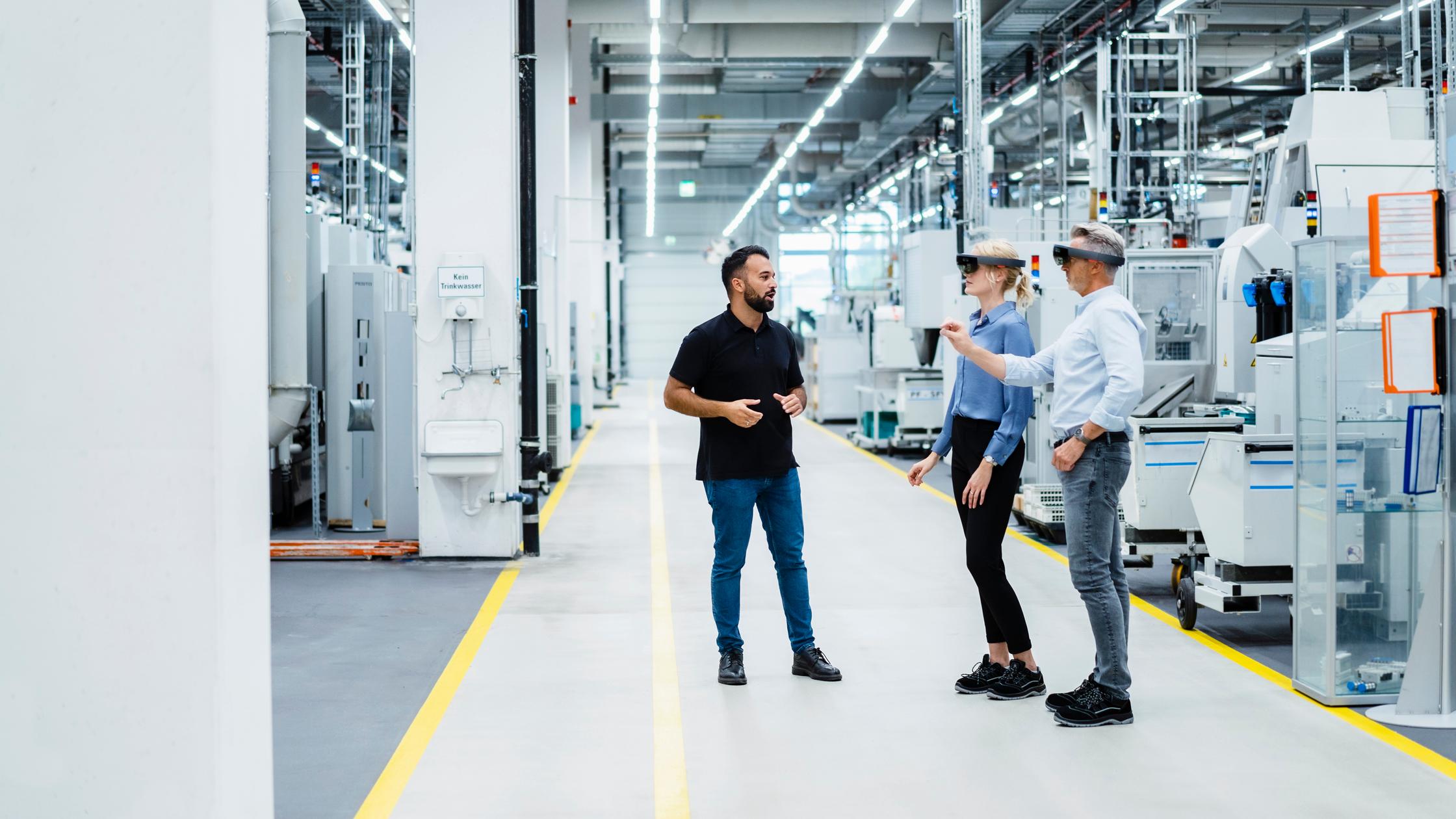 工程师与使用工业增强现实眼镜的男女商人进行讨论