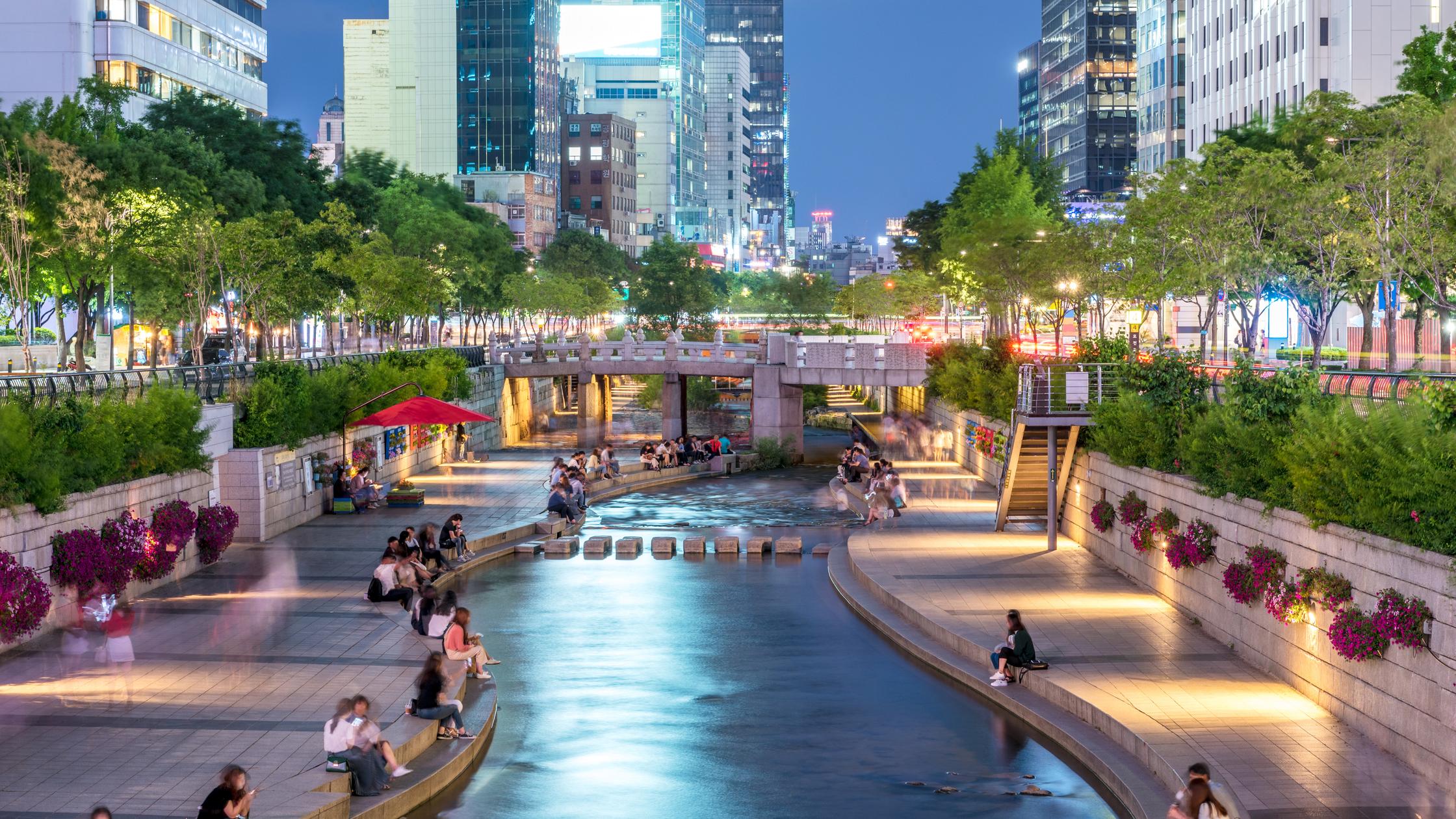 建造环境 - 人们坐在河边使用数码设备