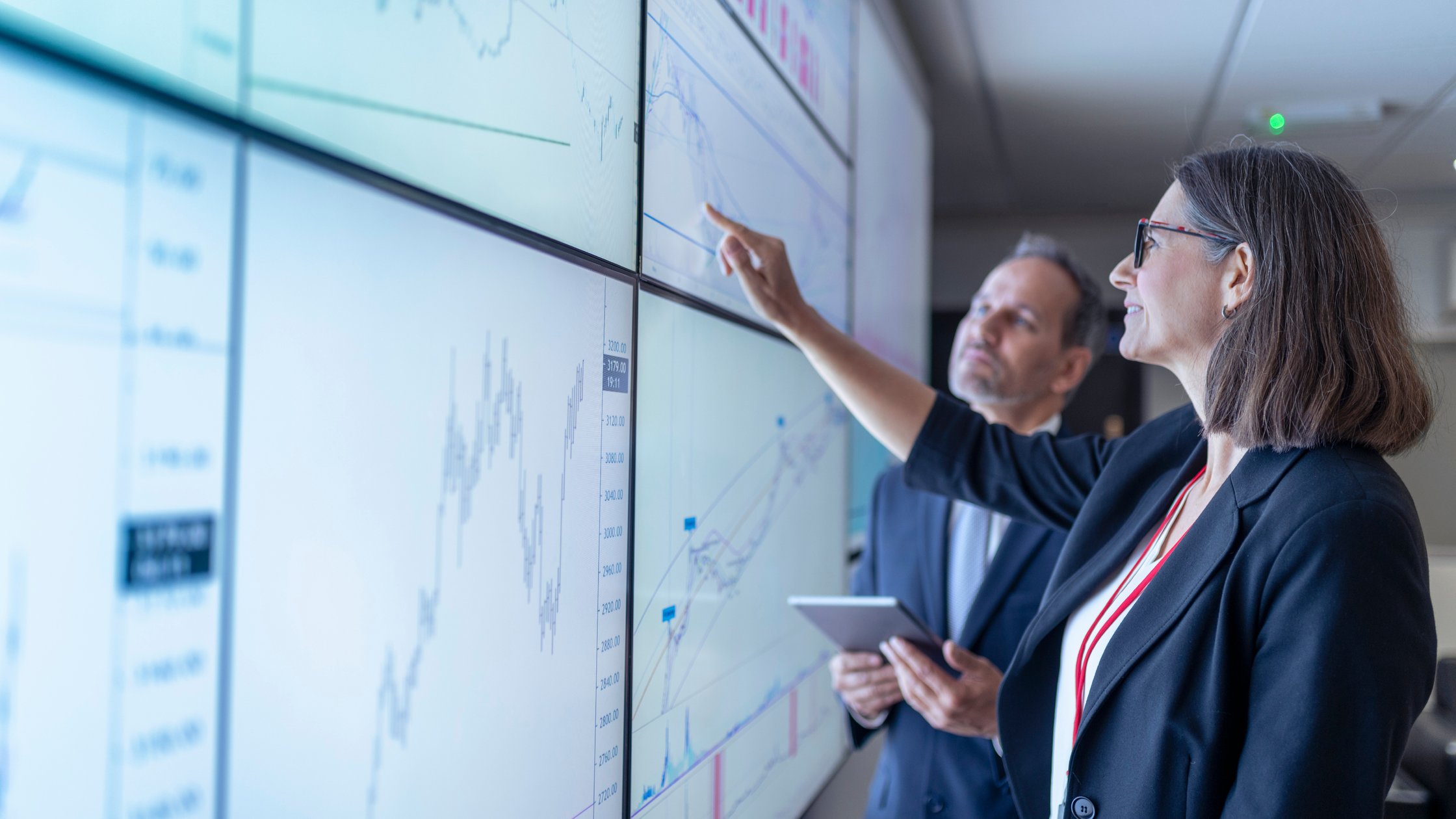 商务人士在交互式屏幕上操作图表