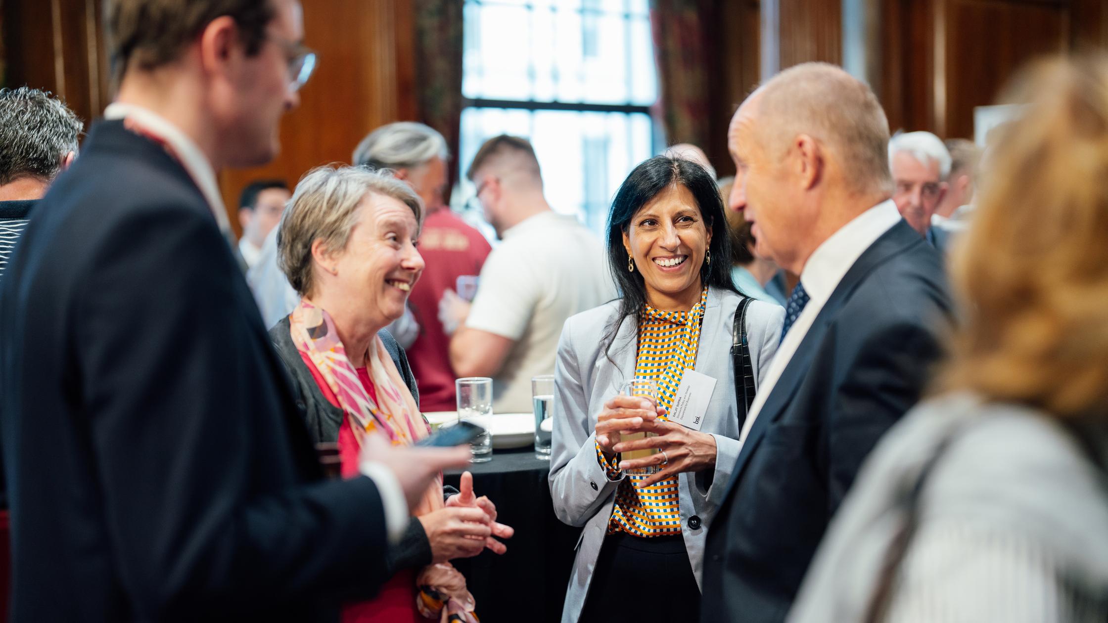 一大群人在繁忙的会议室里参加标准会议并交谈